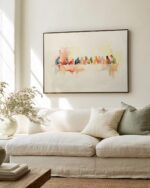 The Last Supper watercolour print in a slim black frame above a cream linen sofa, colourful Luke 22:19 Christian wall art in a sunlit neutral living room.