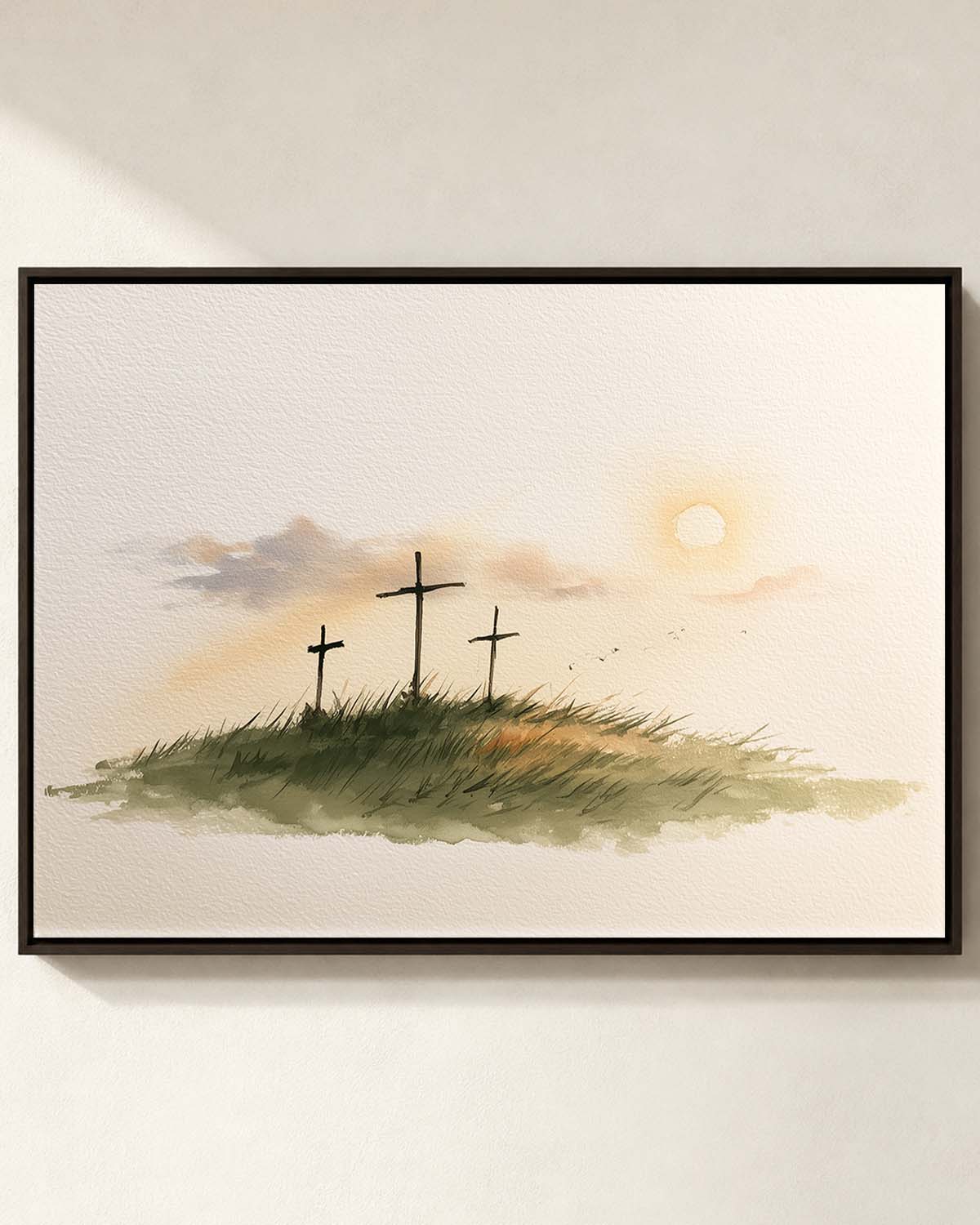 Three Crosses at Calvary Framed Canvas Print - espresso frame on a cream wall Three Crosses at Calvary framed canvas print in an espresso frame on a cream wall, three crosses on a grassy hill at sunrise, Luke 23:33